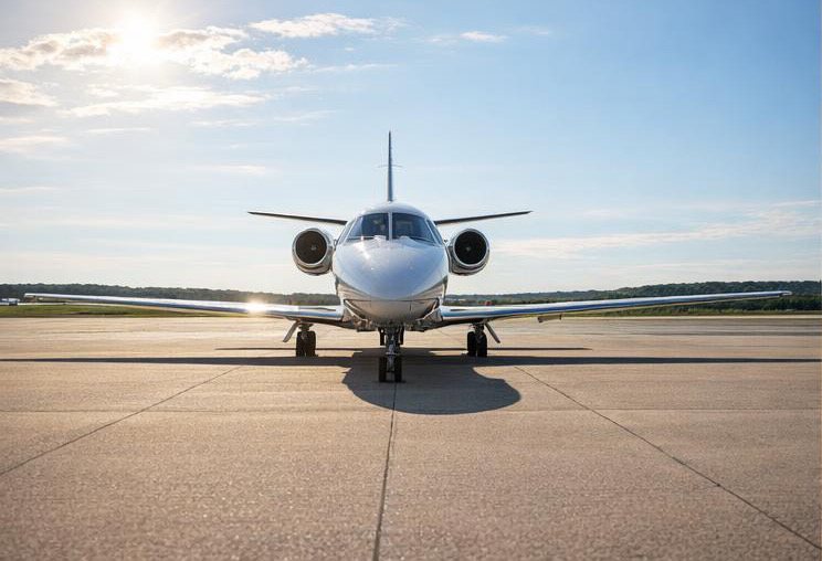 White business jet photographed from the front in daylight