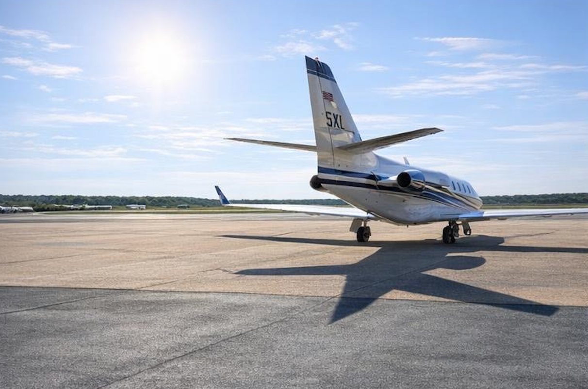 White jet rear quarter view with strong aircraft shadow